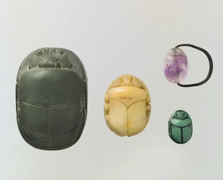 Quatro escaravelhos egípcios esculpidos em pedras de cores diferentes